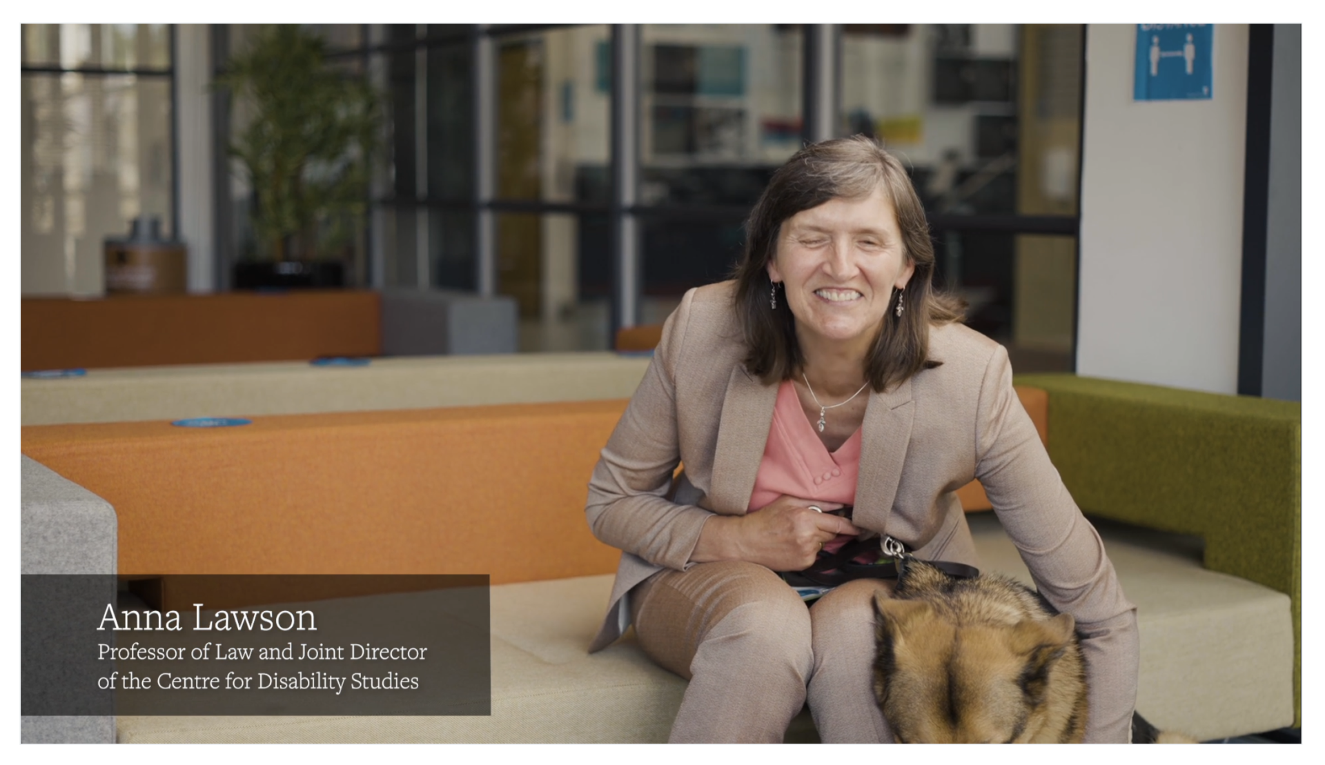 Professor Anna Lawson sitting with her guide dog